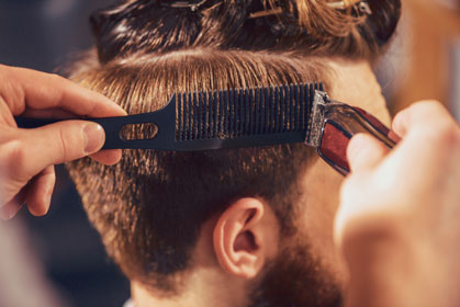Foto von einem Herrenkopf von hinten während eines Haarschnittes